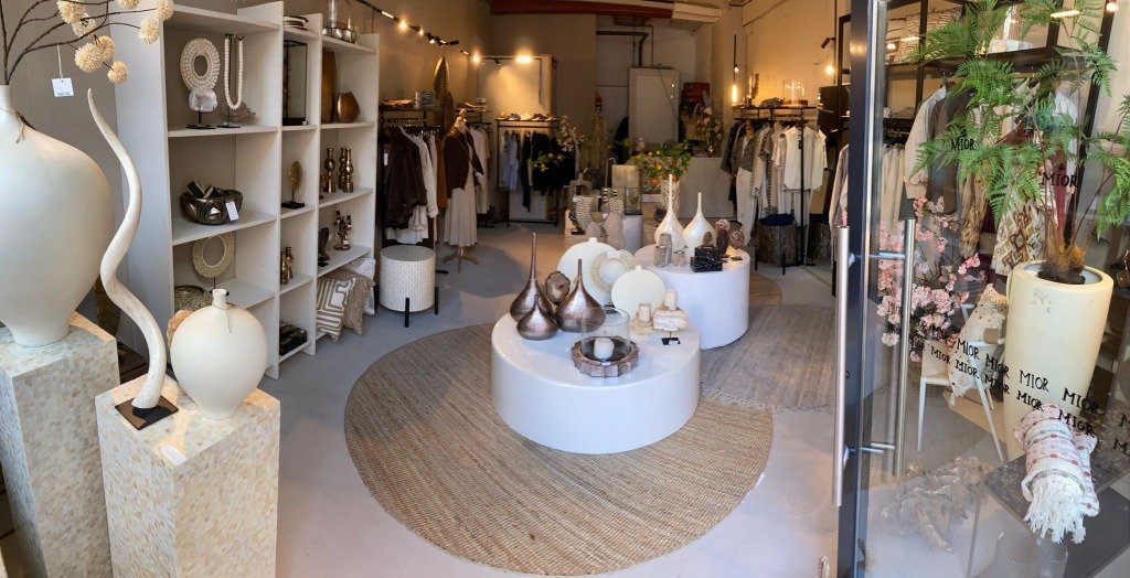 MIOR Boutique Interieur met parelmoer zuilen, keramische vazen, zijden bloemen en InWear mode